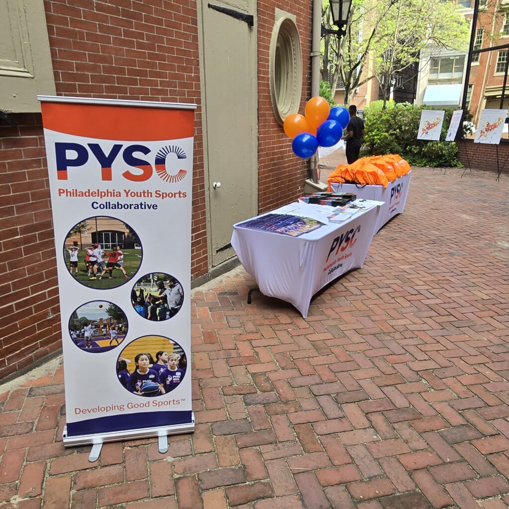PYSC banner, merch, and balloons in the courtyard at Friends Center.